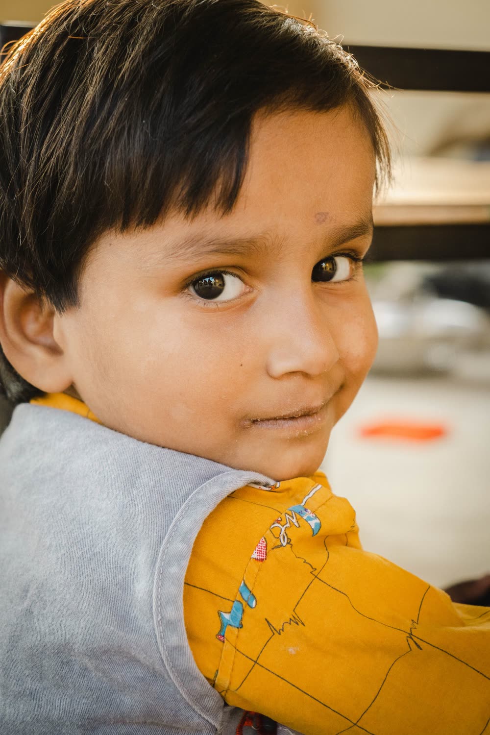 A young boy smiling over his shoulder